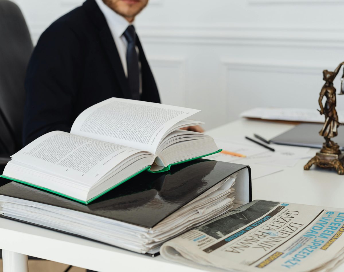 Un carnet et des documents posés sur une table évoquent un cadre clair et organisé.