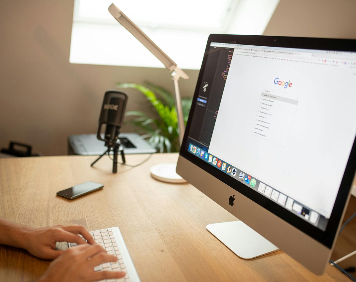 Un espace de travail simple avec ordinateur, smartphone et carnet évoque l’accompagnement numérique.