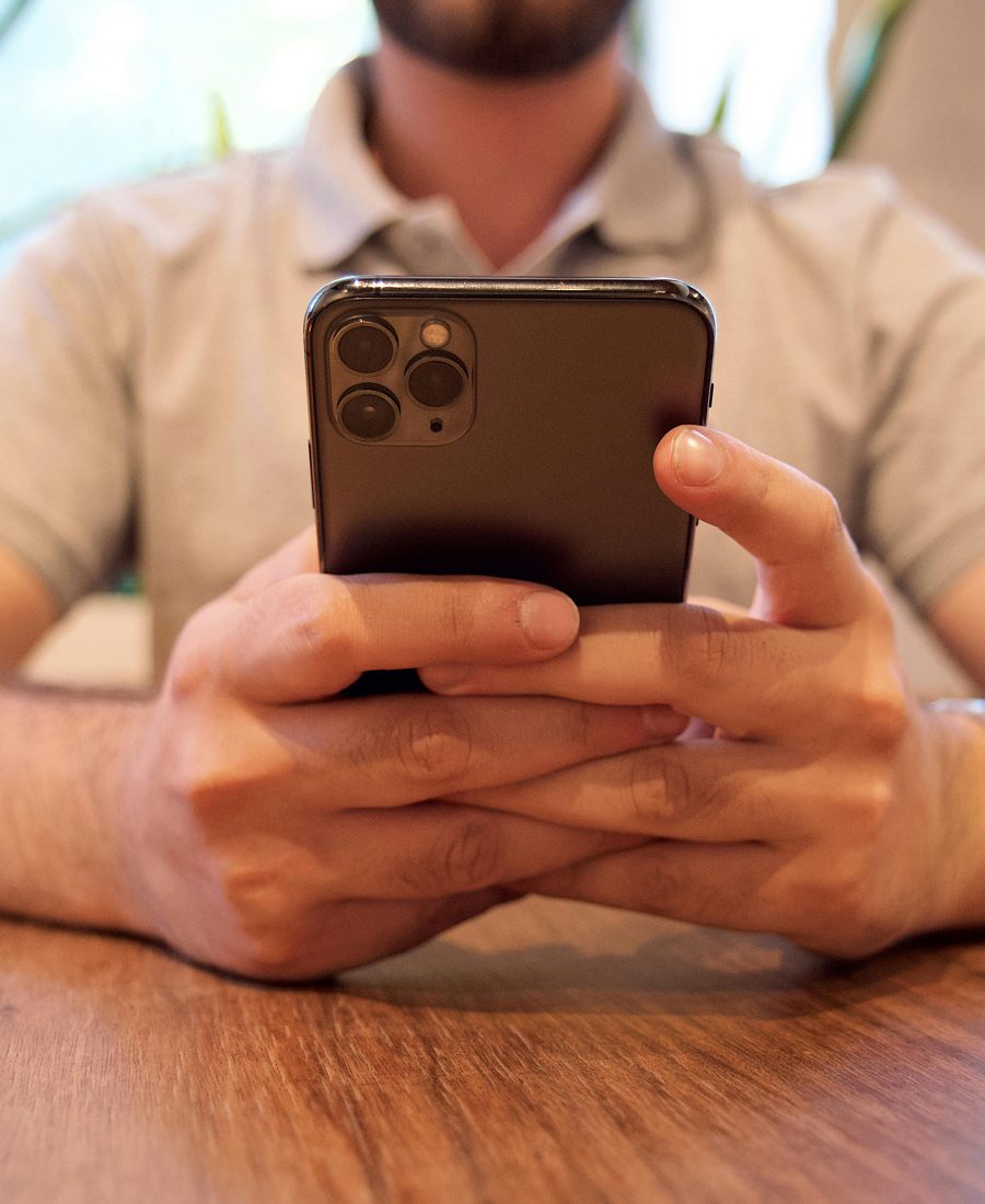 Deux personnes utilisent un smartphone ensemble pendant un accompagnement numérique.